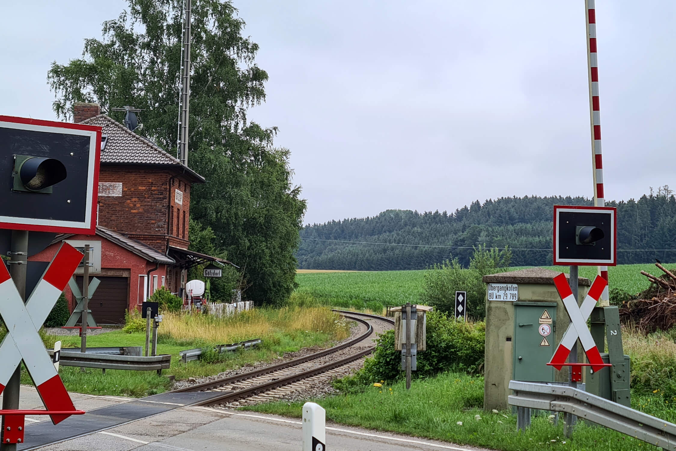 Ein Bahnübergang mit Schranke und Rotlicht