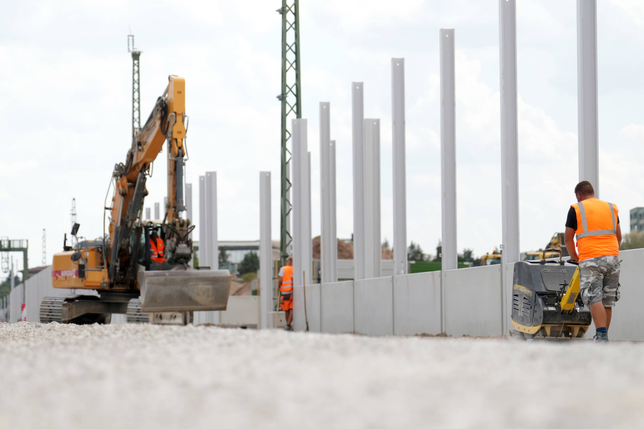 Ein Bagger arbeitet an einer Lärmschutzwand